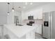 Modern kitchen features an island, stainless steel appliances, white cabinets, and quartz countertops at 162 Nw 42Nd Pl, Ocala, FL 34475