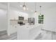 Modern kitchen featuring an island with quartz countertops, stainless steel appliances, and gray wood flooring at 162 Nw 42Nd Pl, Ocala, FL 34475