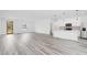 Bright living room with gray wood flooring and open floor plan to a kitchen with modern white cabinets at 162 Nw 42Nd Pl, Ocala, FL 34475