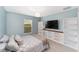 Bedroom with light blue walls, a window, built-in shelving, and light gray plank flooring at 16605 Sw 31 Cir, Ocala, FL 34473