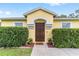 Inviting front entrance with a decorative door, potted plants, and neatly trimmed hedges at 16605 Sw 31 Cir, Ocala, FL 34473