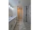 Modern bathroom with double vanity, tile floors, and a glass-enclosed shower at 20 Malauka Trail Crse, Ocklawaha, FL 32179
