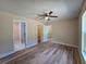 Comfortable bedroom showcasing wood-look flooring, ceiling fan and ensuite bathroom at 20 Malauka Trail Crse, Ocklawaha, FL 32179