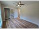 Well-lit bedroom featuring wood-look flooring, ceiling fan and closet at 20 Malauka Trail Crse, Ocklawaha, FL 32179