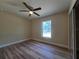 Bright bedroom featuring wood-look floors, a window, and a ceiling fan at 20 Malauka Trail Crse, Ocklawaha, FL 32179