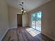 Bright dining room featuring wood floors, modern chandelier, and sliding glass door to outdoor space at 20 Malauka Trail Crse, Ocklawaha, FL 32179
