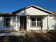 Inviting front entrance featuring new construction with a brown door and well manicured lawn at 20 Malauka Trail Crse, Ocklawaha, FL 32179