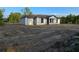 New one-story home with a garage, white exterior, and brown trim awaiting landscaping at 20 Malauka Trail Crse, Ocklawaha, FL 32179