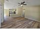 Open-concept living room featuring modern flooring, a ceiling fan, and a view into the kitchen at 20 Malauka Trail Crse, Ocklawaha, FL 32179