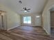 Inviting living room with wood-look floors, ceiling fan, and a clear view of the front door at 20 Malauka Trail Crse, Ocklawaha, FL 32179