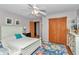 Cozy bedroom featuring a floral rug, ceiling fan, dresser, and wood-paneled closet at 23608 Ne 124 Place Rd, Salt Springs, FL 32134