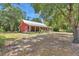 A charming home with a metal roof and a beautiful yard, nestled among mature trees and lush landscaping at 23608 Ne 124 Place Rd, Salt Springs, FL 32134