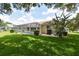 Spacious backyard with lush green lawn and screened pool offers a serene setting for leisure and relaxation at 2478 Nw 50Th Ave, Ocala, FL 34482
