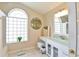 Bright bathroom with decorative art, a unique vanity, and a large, eye-catching window at 2478 Nw 50Th Ave, Ocala, FL 34482