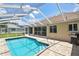 Enclosed pool area with brick pavers, stainless steel grab bar, and outdoor grill provides a relaxing and private space at 2478 Nw 50Th Ave, Ocala, FL 34482