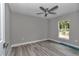 This bedroom features neutral walls, wood-look flooring, a ceiling fan, and a window providing natural light at 3696 Se 139Th Ln, Summerfield, FL 34491