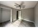 Comfortable bedroom featuring hardwood floors, a ceiling fan, and a spacious closet at 3696 Se 139Th Ln, Summerfield, FL 34491