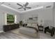 Bedroom with tray ceiling, fan, bedside tables and lamps, soft rug and tree view at 3696 Se 139Th Ln, Summerfield, FL 34491