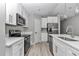 Well-lit kitchen featuring white cabinets, stainless steel appliances, and stylish countertops at 3696 Se 139Th Ln, Summerfield, FL 34491