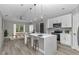 Open kitchen with white cabinets, stainless steel appliances, and a large island with seating at 3696 Se 139Th Ln, Summerfield, FL 34491
