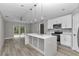 Spacious kitchen featuring a large island, white cabinets, stainless steel appliances, and modern finishes at 3696 Se 139Th Ln, Summerfield, FL 34491