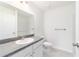 This bathroom features white cabinets, a sink, a toilet, gray countertops, and light wood-look flooring at 37 Teak Run, Ocala, FL 34472