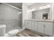 Bathroom showcasing a double vanity with granite countertops, a large mirror, and a tiled walk-in shower at 4609 Ne 7Th St, Ocala, FL 34470
