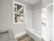 Bathroom featuring a tub with white tile and a window at 4609 Ne 7Th St, Ocala, FL 34470