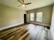This bedroom has 2 large windows, a door, hardwood floors, and a ceiling fan at 4609 Ne 7Th St, Ocala, FL 34470