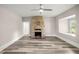 Spacious living room featuring a stone fireplace, wood floors, ceiling fan and natural light at 4609 Ne 7Th St, Ocala, FL 34470