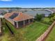Aerial view of a home's backyard with lanai, solar panels, and privacy fence at 5587 Nw 40Th Pl, Ocala, FL 34482
