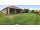 Backyard featuring a screened lanai, mature landscaping, and secure fencing at 5587 Nw 40Th Pl, Ocala, FL 34482
