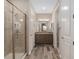 Bathroom boasts a glass shower, granite vanity, and modern wood-look tile flooring at 5587 Nw 40Th Pl, Ocala, FL 34482