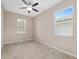 Bright bedroom featuring neutral carpeting, fan, and windows with blinds at 5587 Nw 40Th Pl, Ocala, FL 34482