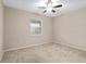 Cozy bedroom with neutral carpet, a ceiling fan, and natural light from the window at 5587 Nw 40Th Pl, Ocala, FL 34482