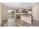 Open-concept kitchen featuring stainless steel appliances, an island, and sliding glass doors leading to the backyard at 5587 Nw 40Th Pl, Ocala, FL 34482