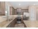 This kitchen is equipped with stainless steel appliances, granite countertops, and stylish wood look tile flooring at 5587 Nw 40Th Pl, Ocala, FL 34482