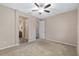 Spacious main bedroom with plush carpeting, a ceiling fan, and an en-suite bathroom at 5587 Nw 40Th Pl, Ocala, FL 34482