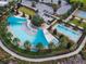 Aerial view of a luxurious community pool area with a large pool and splash pad surrounded by palm trees at 5587 Nw 40Th Pl, Ocala, FL 34482