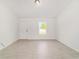 Bright living room features new tile flooring, white walls, and natural light from a single window at 6 Locust Loop Crse, Ocala, FL 34472