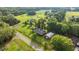 Aerial view of property featuring mature trees, a home, a red barn, and a long driveway at 6497 W Anthony Rd, Ocala, FL 34479