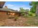 Backyard featuring a brick patio, brick accents, a small patio cover, and mature shade trees at 6497 W Anthony Rd, Ocala, FL 34479