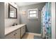 Bathroom vanity with a sink and a mirror, complemented by a shower with a decorative curtain at 6497 W Anthony Rd, Ocala, FL 34479