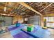 Large garage with exposed rafters, mats, and equipment perfect for gymnastics and other physical activities at 6497 W Anthony Rd, Ocala, FL 34479