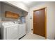 Functional laundry room with white washer and dryer and ample storage space at 6497 W Anthony Rd, Ocala, FL 34479