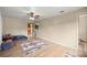 Spacious living room with a ceiling fan, wood-look floors, and natural light, complemented by neutral walls at 6497 W Anthony Rd, Ocala, FL 34479