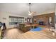 Inviting living room showcasing a brick fireplace, wood floors, and large windows offering ample natural light at 6497 W Anthony Rd, Ocala, FL 34479