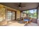 Cozy screened porch with brick accents, stone wall, ceiling fan and cushioned seating at 6497 W Anthony Rd, Ocala, FL 34479