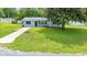 Single-story home with a well-maintained front yard, lovely landscaping and a large shade tree at 6511 Se 25Th Ave, Ocala, FL 34480