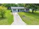 Inviting one-story home featuring tidy landscaping, a concrete driveway, and a welcoming front entrance at 6511 Se 25Th Ave, Ocala, FL 34480